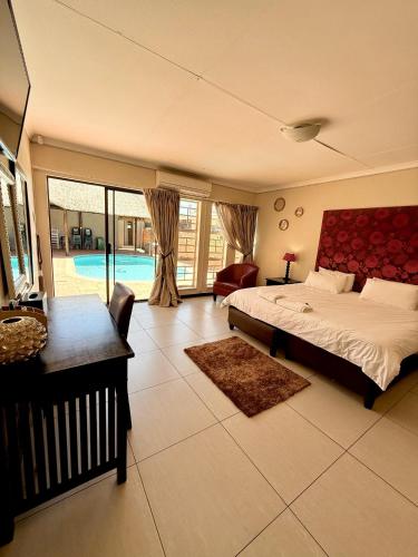 a bedroom with a bed and a living room with a pool at Senate Way Guest House in Kimberley