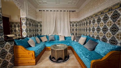 a living room with a blue couch and a table at Appartement near to AirPort 262 avenue el khalij 2 BEDROOM in Marrakech