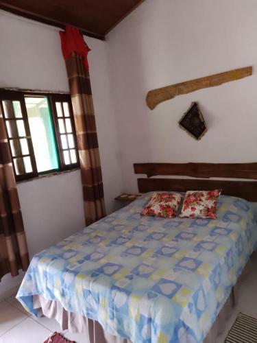 a bedroom with a bed in a room with windows at Chalé do João e do Chico Garfield in Jaboticatubas