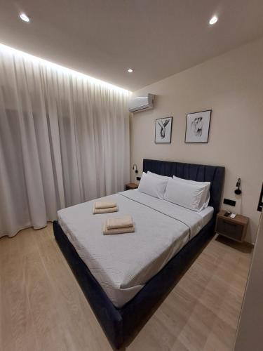a bedroom with a large bed with two towels on it at Serenity Luxury Apartment in Alexandroupoli