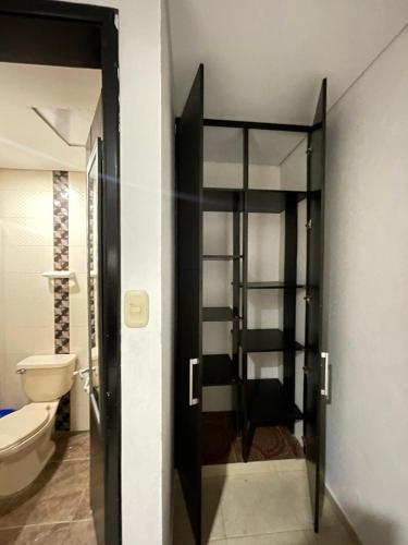 a bathroom with a toilet and a glass door at Casa D`Campo Alegre in Acacías