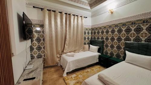 a bedroom with two beds and a television in it at Appartement near to AirPort 262 avenue el khalij 2 BEDROOM in Marrakech