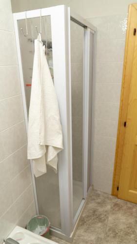 a shower stall with a white towel hanging on it at Kymera Alpine Apartment in Folgarida