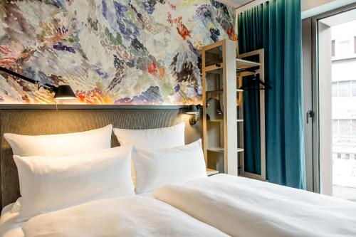 a bedroom with a bed and a painting on the wall at Motel One Antwerp in Antwerp