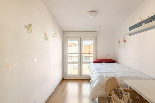 ein Schlafzimmer mit einem Bett und einem Fenster in der Unterkunft apartamento familiar con piscina licencia 14721 in Camarma de Esteruelas