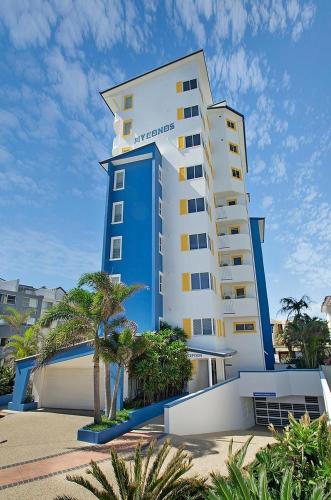 a large building with palm trees in front of it at Myconos Resort in Maroochydore