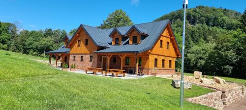 a large wooden house with a black roof at Chalupa Vápenka in Stárkov