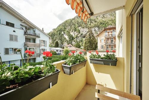 a balcony with pots of flowers on a building at Stay Switzerland Apartments in Interlaken