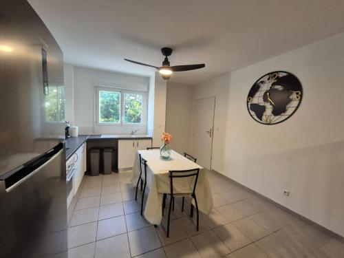 a kitchen with a table and a ceiling fan at Foyal Toloman - Flanboyan lodge in Les Trois-Îlets