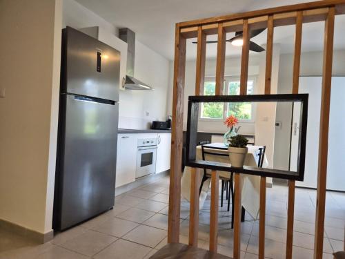 a kitchen with a stainless steel refrigerator and a table at Foyal Toloman - Flanboyan lodge in Les Trois-Îlets