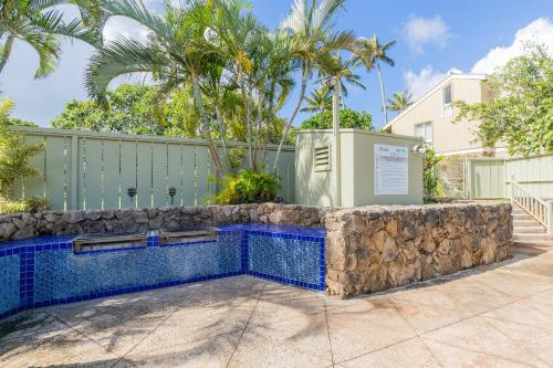 a swimming pool in a yard with a fence and palm trees at The Drifter - North Shore Loft - Relaxed Luxury in Kahuku