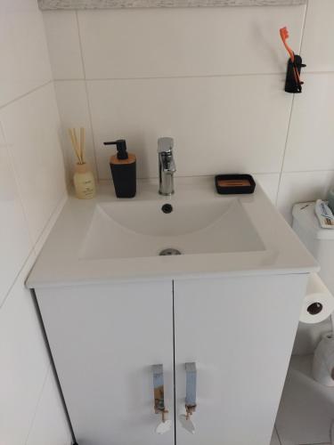 a white sink in a room with a toilet at 21 Pin Oak Guest House in Cape Town
