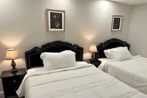 two beds in a bedroom with white sheets and pillows at Lake Anna Lakeside Luxury 6BR w Game Room, Cinema, Hot tub and Grill in Bumpass