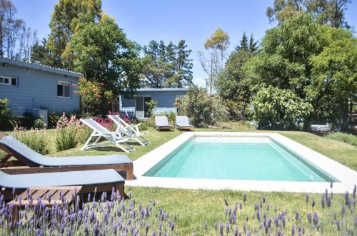 Una piscina en un patio con sillas y una casa. en Tiny House Entre Las Sierras Solo Adultos, en Villa Giardino