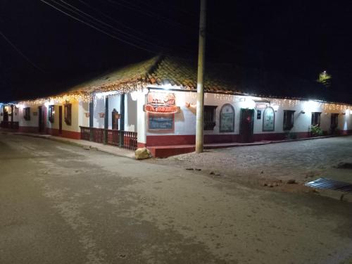 a building with a sign on the side of it at night at Hostal Santa Isabel in Iza