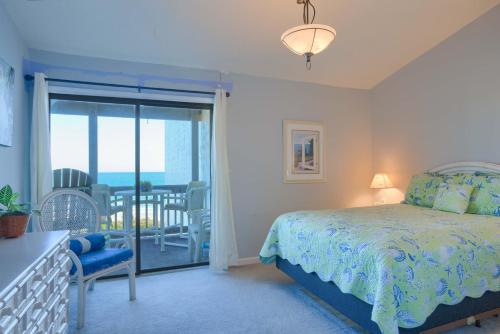 a bedroom with a bed and a balcony with the ocean at Oceanfront Resort - Swimming Pool - Tennis in Chadwick Acres
