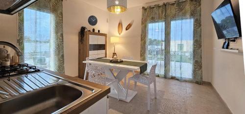 a kitchen with a sink and a table and some windows at Dionysus Luxury Villa in Brucoli