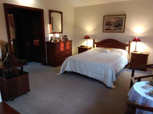 a bedroom with a bed and two tables and a mirror at Chalet ALTOS DEL PINAR in Punta del Este