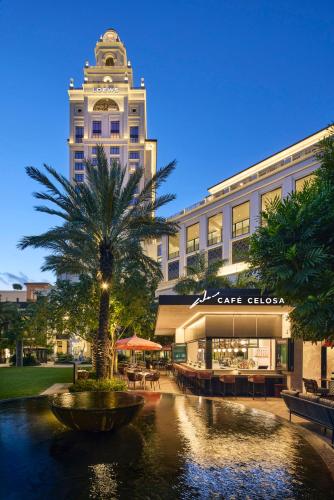 a building with a palm tree in front of a building at Loews Coral Gables Hotel in Miami
