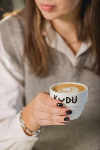 a woman is holding a cup of coffee at Ace Hotel & Swim Club Athens in Athens