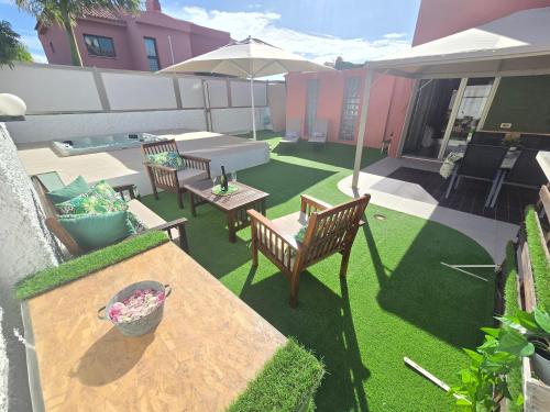 a patio with a table and chairs and an umbrella at Oasis House in Maspalomas