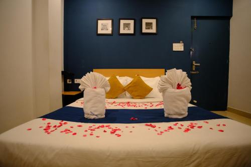 a bedroom with a bed with red flowers on it at Blue City Palace - Near Chennai Airport in Chennai