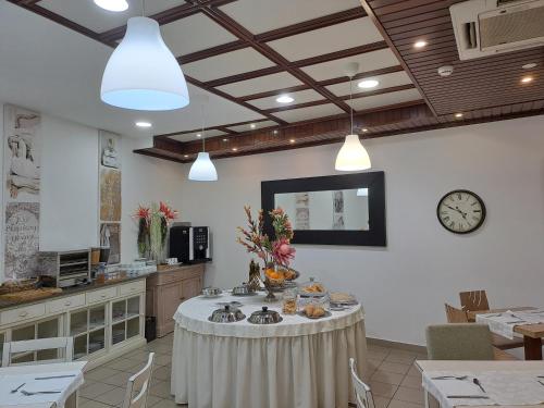 a dining room with a table and a clock on the wall at Hotel SQUARE in Sertã