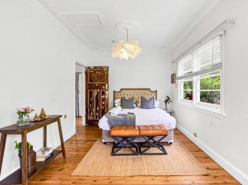 a bedroom with a bed and a table and a window at Tranquil Blue Cottage Close to Eco Point in Katoomba