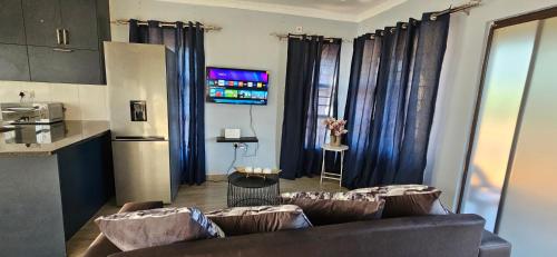 a living room with two couches and a kitchen at BlissfulBreeze stays in Palatswe