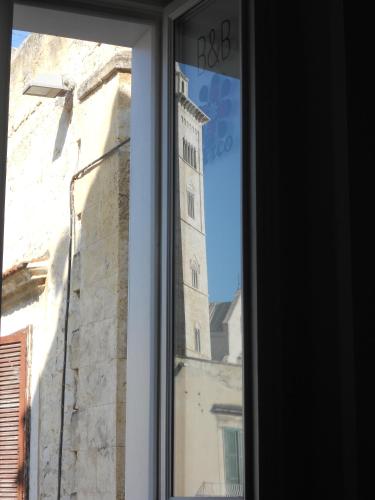 a reflection of a clock tower in a window at Arco' B&B Trani Cattedrale in Trani