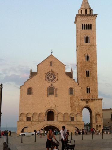 a large building with a clock tower in front of it at Arco' B&B Trani Cattedrale in Trani