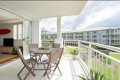 a patio with a table and chairs on a balcony at The Pool Resort Kingscliff - Private Apartments by Holiday Management Company in Kingscliff