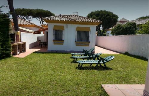 a group of benches in a yard with a building at Santa Ana in Novo Sancti Petri