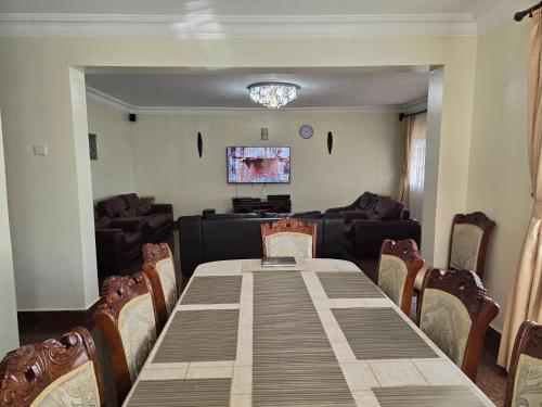 a dining room with a table and a couch at Akright Villa in Buzzi