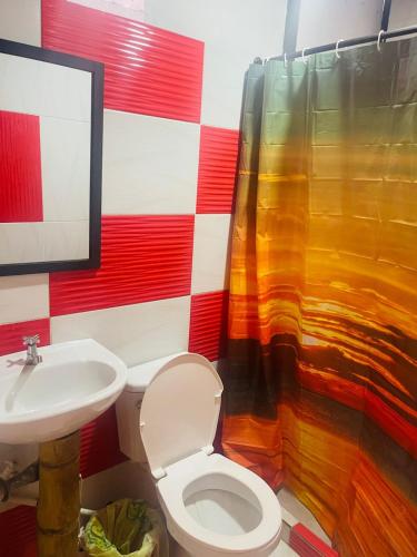 a bathroom with a toilet and a sink at EL EDEN HABITACIONES in Manizales