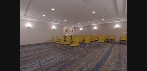 a row of yellow chairs in a room at Holiday Inn Express Hartford-Newington by IHG in Newington