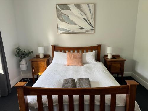 una camera con letto in legno e 2 cuscini di Heritage Charm, Modern Comfort a Ballarat