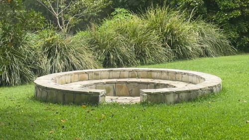 a fire pit in the middle of the grass at BELLINGEN CONVERTED CHURCH on the river (Pet Friendly) in Bellingen