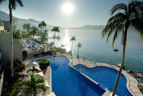 a swimming pool with a view of the water at Camino Real Acapulco Diamante in Acapulco