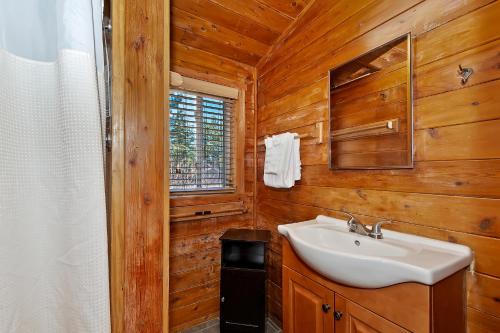 een badkamer met een witte wastafel en houten wanden bij NEW- Red Robin W hot tub in Big Bear Lake