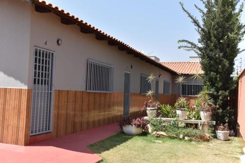 a house with a wooden fence and a yard at Casa da Vó Maria 10 in Goiânia