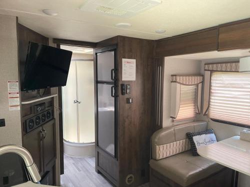 タラハシーにあるCozy Caravan near Capitol FSU FAMUの小さな客室で、テレビ、キッチンが備わります。