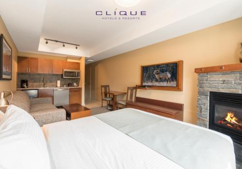a hotel room with a bed and a fireplace at Falcon Crest Lodge by CLIQUE in Canmore