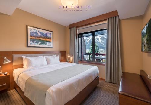 a hotel room with a bed and a window at Falcon Crest Lodge by CLIQUE in Canmore