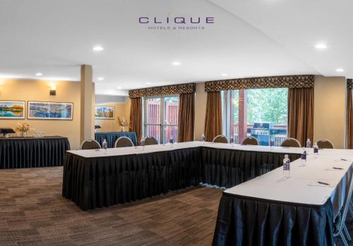 a conference room with tables and chairs in it at Falcon Crest Lodge by CLIQUE in Canmore
