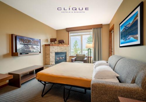 a bedroom with a bed and a couch and a fireplace at Falcon Crest Lodge by CLIQUE in Canmore