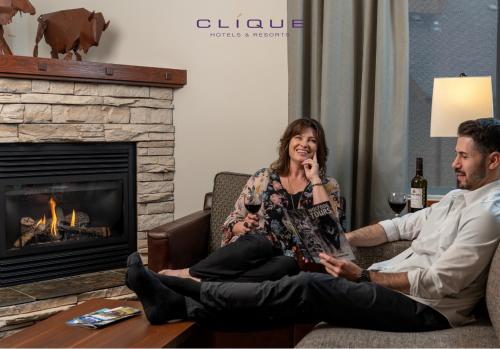 a woman sitting on a couch next to two men at Falcon Crest Lodge by CLIQUE in Canmore