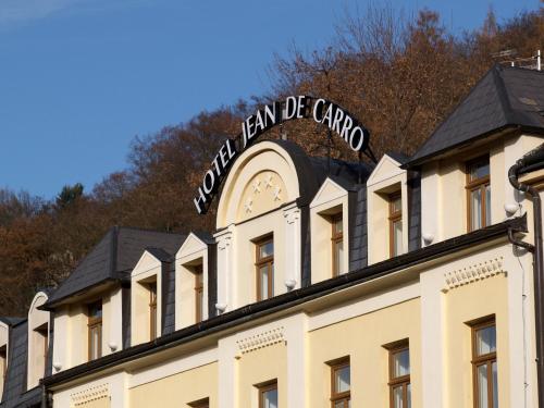 a building with a sign on top of it at Wellness Hotel Jean De Carro in Karlovy Vary
