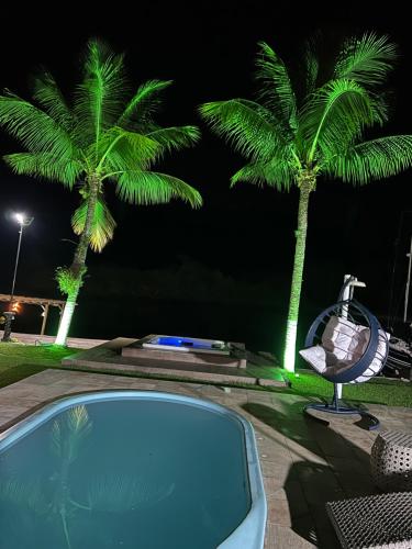 un'auto parcheggiata accanto a due palme di notte di Angra dos Sonhos ad Angra dos Reis