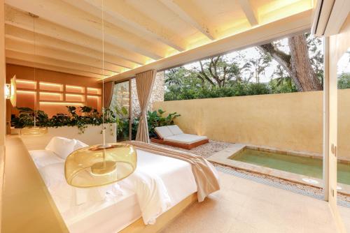 a bedroom with a bed with a table and a tub at Arde La Selva in Santa Fe de Antioquia